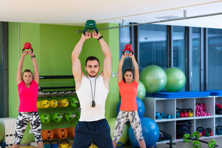 Kettlebells swing exercise man and woman workout at gym