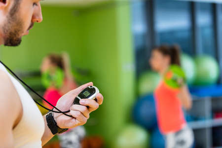 Two girl exercising at the gym with a personal trainer.の写真素材
