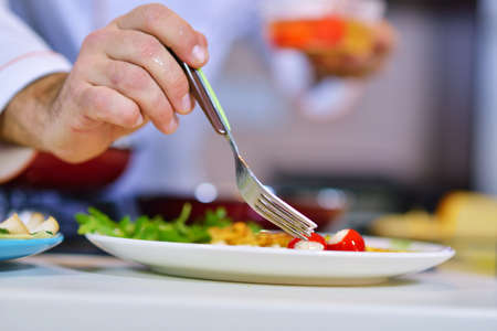 Mans hand holding an egg. White chicken egg. Chef starts preparing omelet.