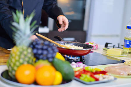 mature chef preparing a meal with various vegetables and meat