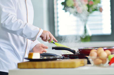 mature chef preparing a meal with various vegetables and meat