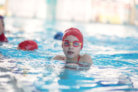 happy children kids group at swimming pool class learning to swimの写真素材