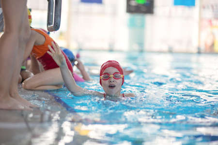 happy children kids group at swimming pool class learning to swimの写真素材
