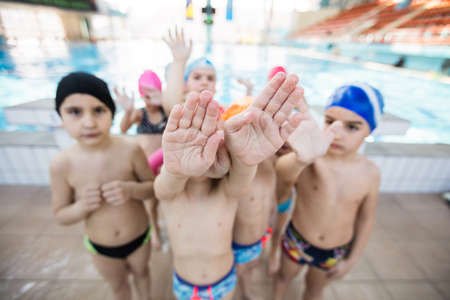 happy children kids group at swimming pool class learning to swim