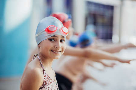 Little girl in googles swim in poolの写真素材