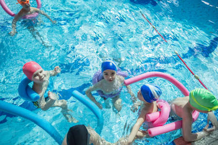 happy children kids group at swimming pool class learning to swimの写真素材