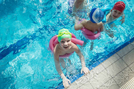 happy children kids group at swimming pool class learning to swimの写真素材