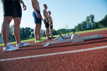 Male athletics runners on starting line without shirts.の写真素材