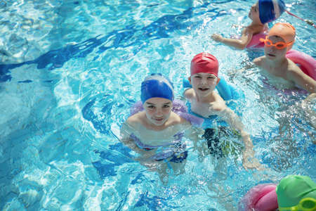happy children kids group at swimming pool class learning to swimの写真素材