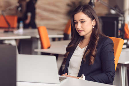 Young pretty business woman with notebook in the office