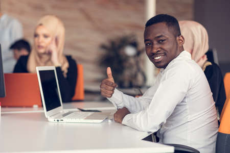 Multiracial contemporary business people working connected with technological devices like tablet...