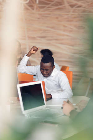 Handsome successful African American looking at the screen with serious face expression at modern startup office.の写真素材