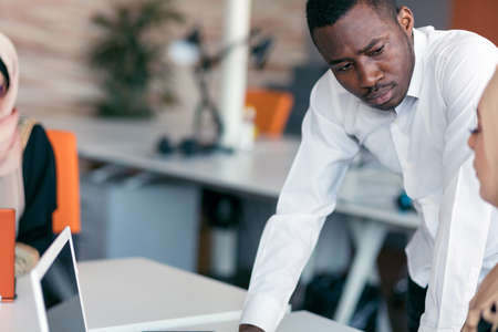 Multiracial contemporary business people working connected with technological devices like tablet and laptop, talking together - finance, business, technology conceptの写真素材
