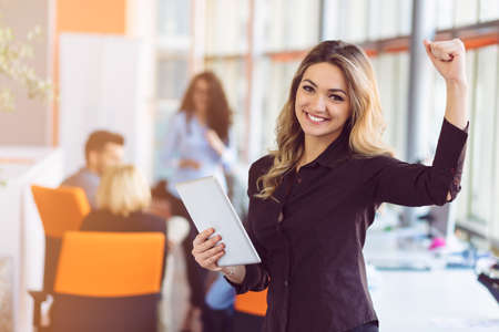 portrait of young business woman at modern startup office interior, team in meeting in backgroundの写真素材