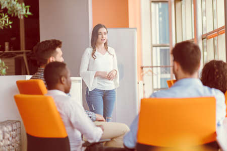 Pretty young business woman giving a presentation in conference or meeting setting.