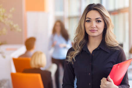 Team work discussing. Young woman with paper folder.の写真素材