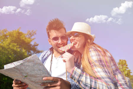 Cheerful young couple on a sunny day reading map