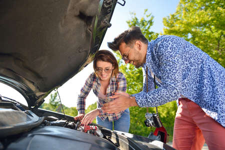 Young couple on the road has problems with their carの写真素材