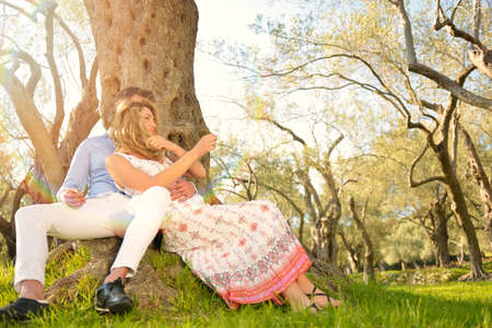 couple relax under the tree. Fine art style. Olive garden.の写真素材