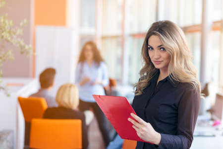 Team work discussing. Young woman with paper folder.の写真素材