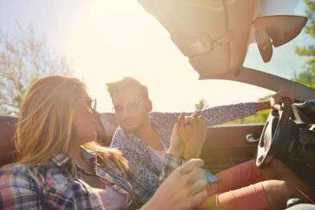 Couple of lovers driving on a convertible car - Newlywed pair on a romantic date