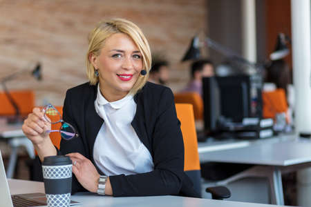 Customer service representative at work. Beautiful young woman in headset working at the computer