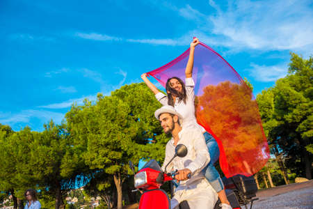 Happy free freedom couple driving scooter excited on summer holidays vacation.の写真素材