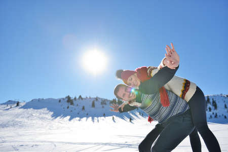 Loving couple playing together in snow outdoor.の写真素材