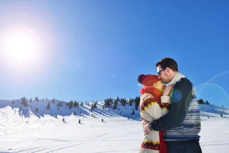 Happy couple playful together during winter holidays vacation outside in snow parkの写真素材