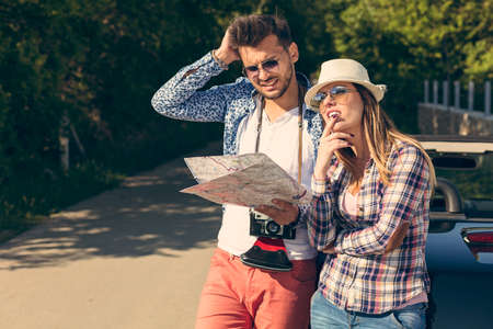 confused friends with map looking at the map at cabriolet car