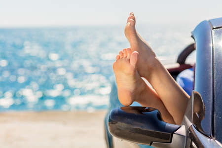 Girl having fun in blue cabriolet against toned sky background. Summer vacation and travel conceptの写真素材