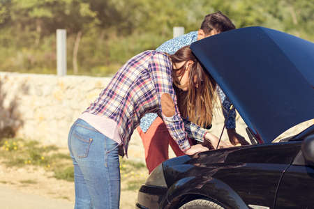 Young couple after a car breakdown at the side of the roadの写真素材