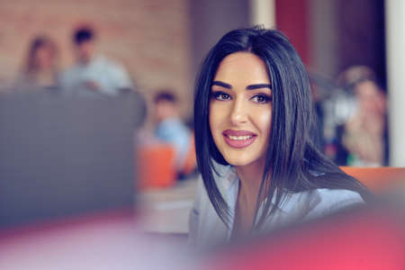 Businesswoman sits at a desk in front of a computerの写真素材