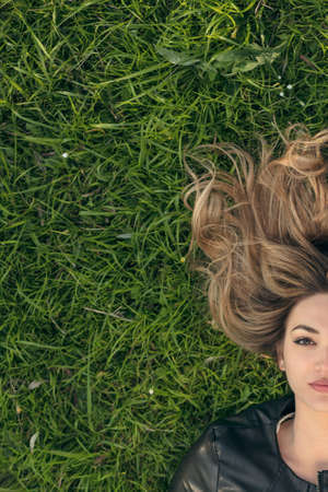 Teenage girl laying in grassの写真素材