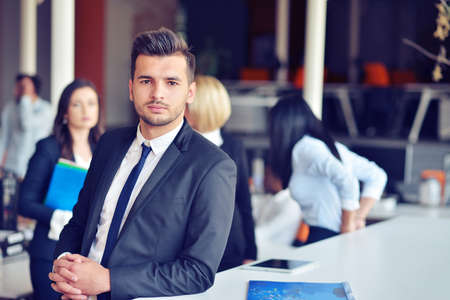Portrait of an handsome businessman in front of his teamの写真素材
