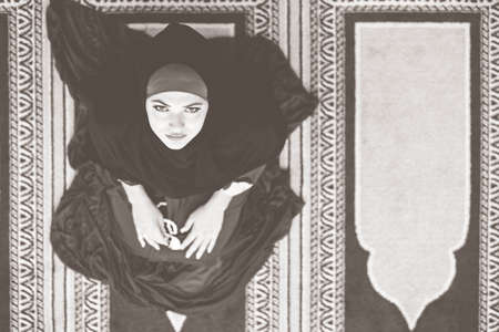 Top aerial view Young beautiful Muslim Woman Praying In Mosqueの写真素材