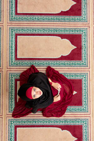 Top aerial view Young beautiful Muslim Woman Praying In Mosqueの写真素材