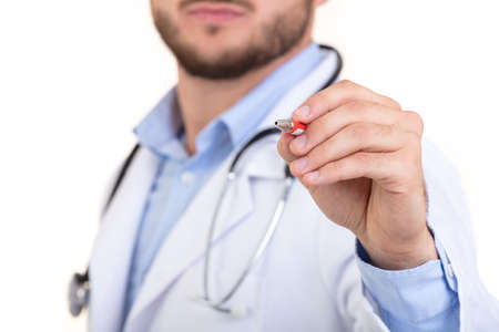Doctor hand with a pen pointing on whiteの写真素材