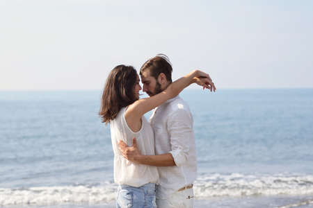 Romantic young couple on the beach kissing.の写真素材