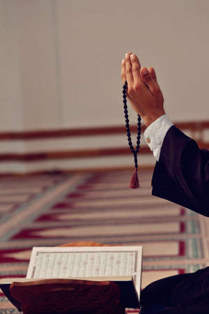 Hand of muslim people praying with mosque interior background