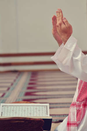 Hand of muslim people praying with mosque interior background