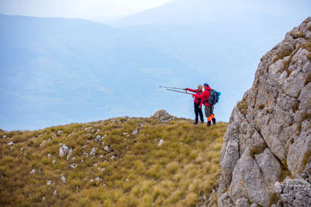 Adventure, travel, tourism, hike and people concept - Smiling couple walking with backpacks outdoorsの写真素材