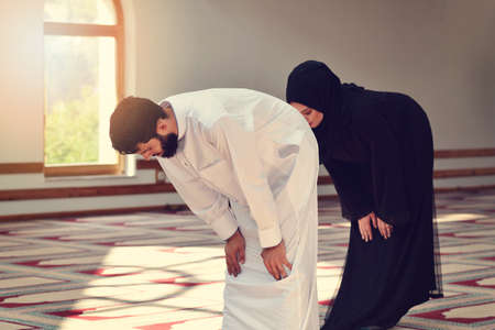 Muslim man and woman praying in mosqueの写真素材