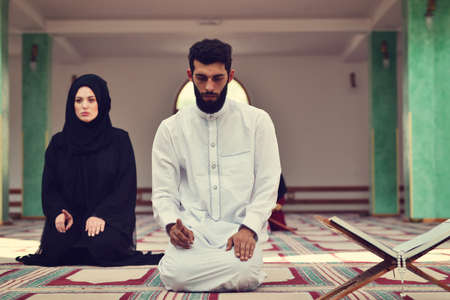 Muslim man and woman praying in mosqueの写真素材