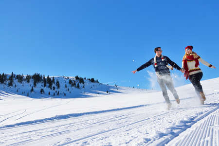 Couple having fun running down slopeの写真素材