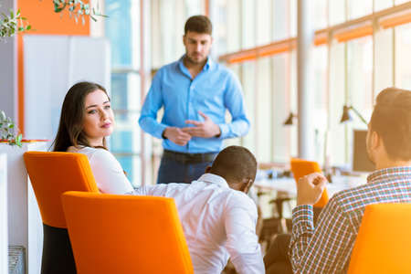 Group of casually dressed businesspeople discussing ideas in the office.
