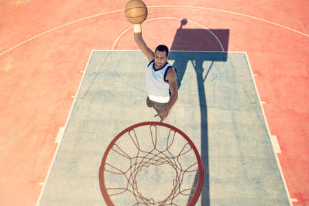 High angle view of basketball player dunking basketball in hoop