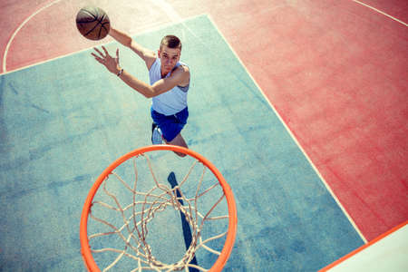 High angle view of basketball player dunking basketball in hoopの写真素材