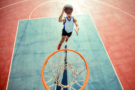 High angle view of basketball player dunking basketball in hoopの写真素材