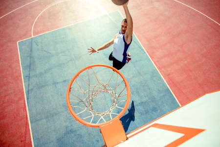High angle view of basketball player dunking basketball in hoopの写真素材